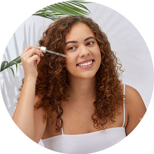 Model applying Malibu C vitamin C serum to face to improve appearance of complexion